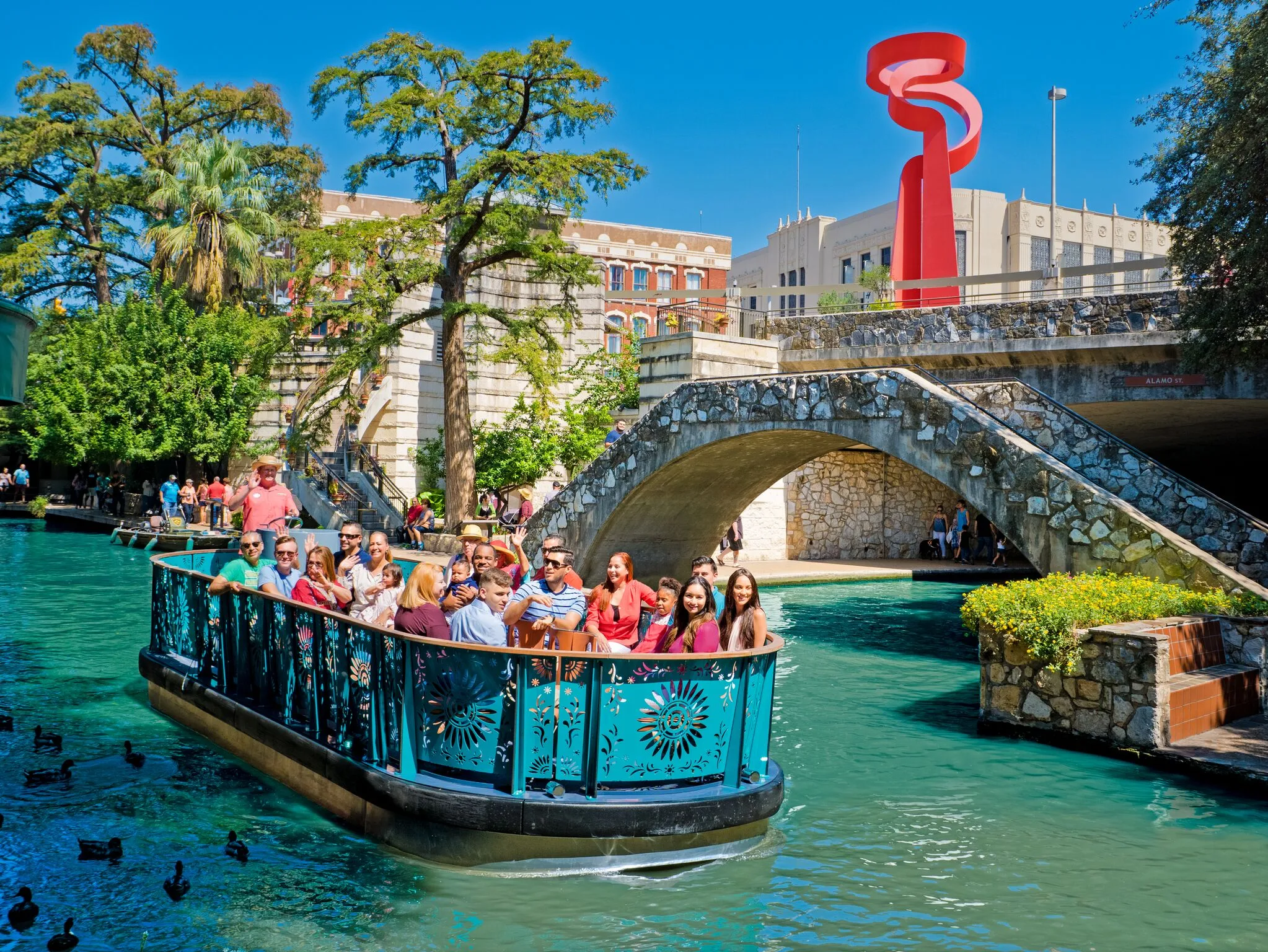Families enjoying a river cruise on the San Antonio River Walk