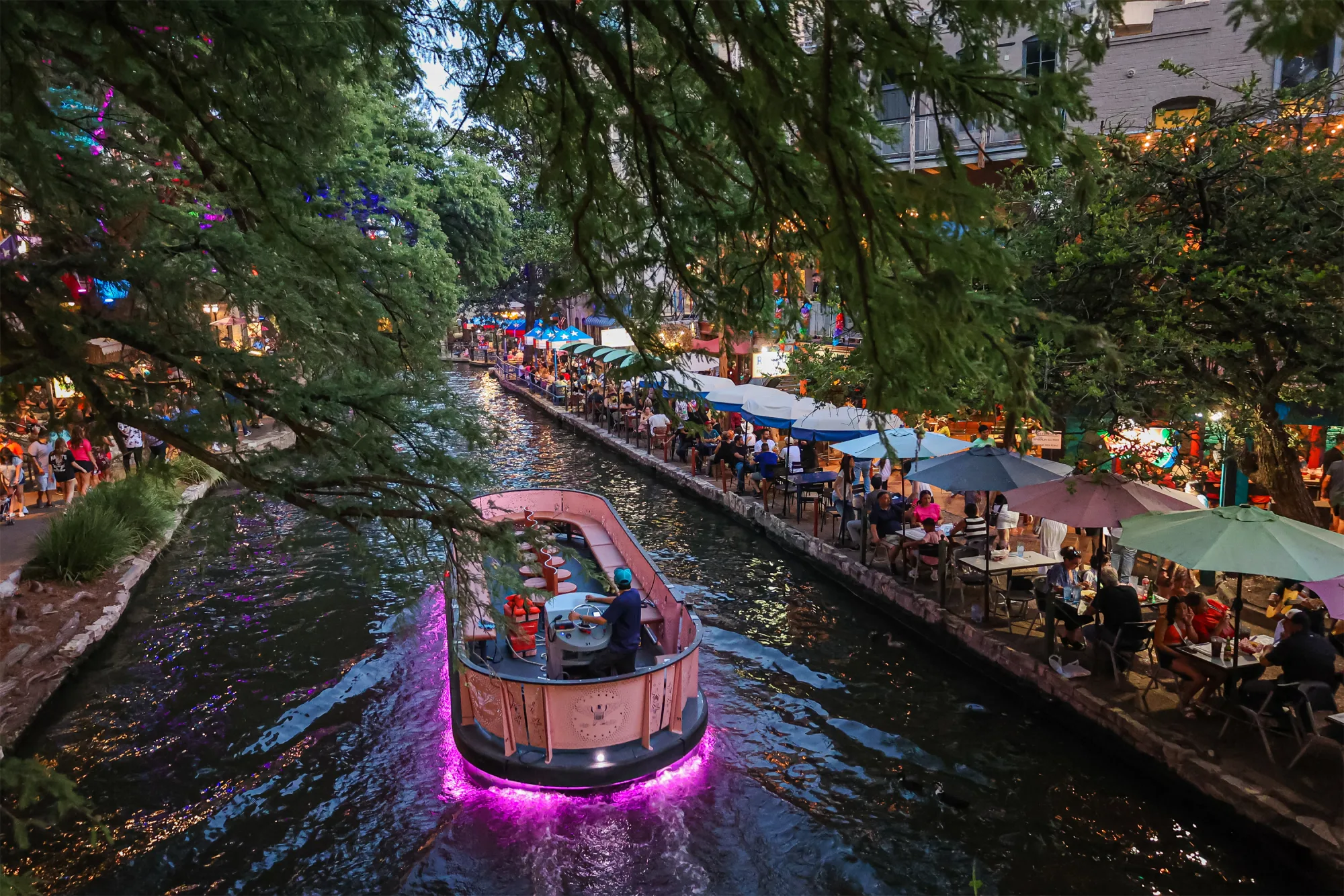 San Antonio River Walk with river boats, restaurants, and visitors