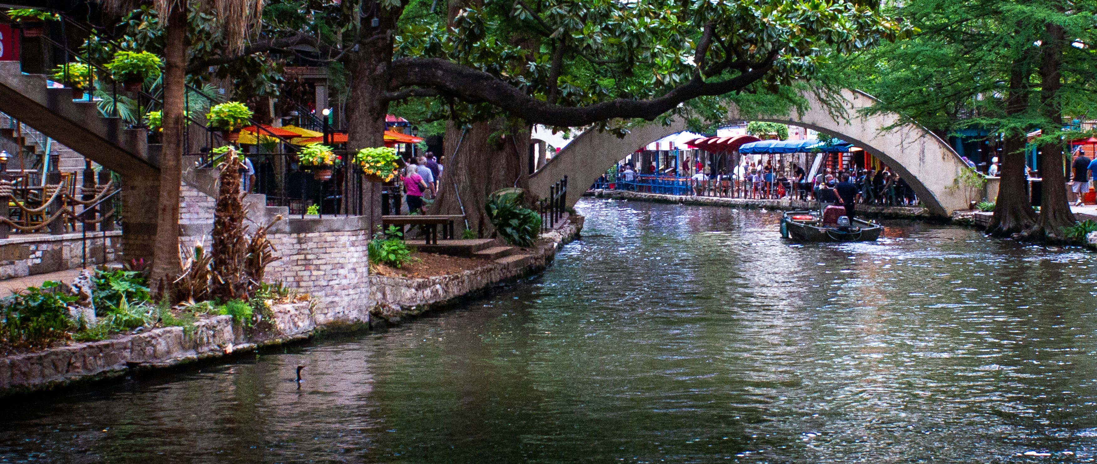 San Antonio River Walk with the river, restaurants, and colorful umbrellas